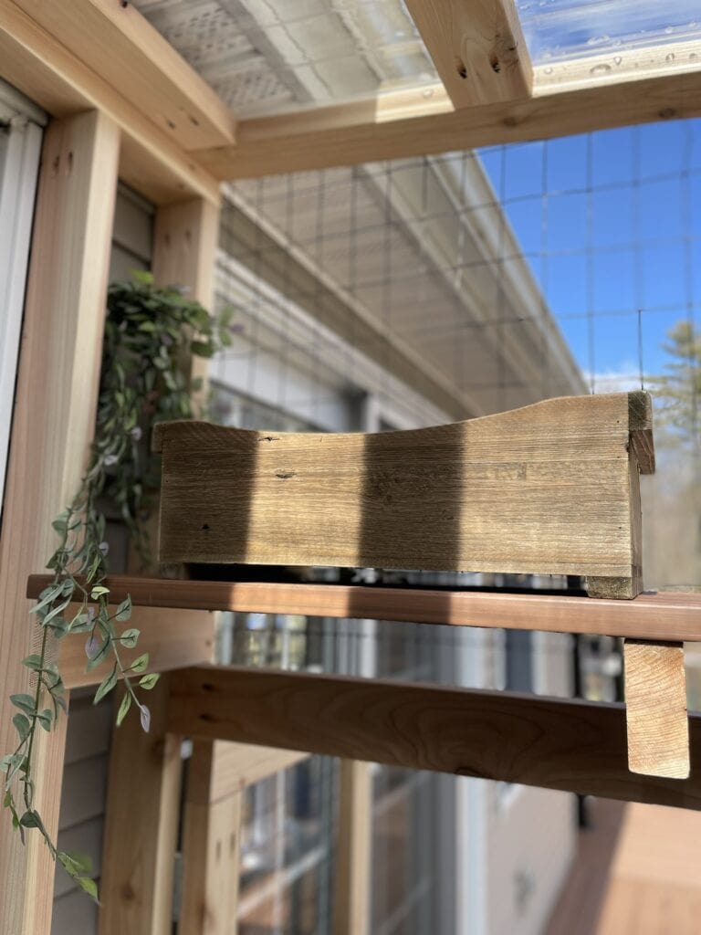 wooden cat bed in a catio