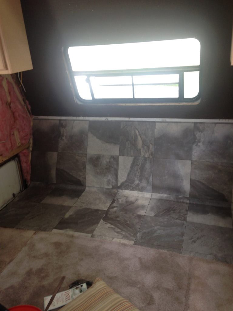 Installing the flooring in the storage area.  Camper remodel before and after