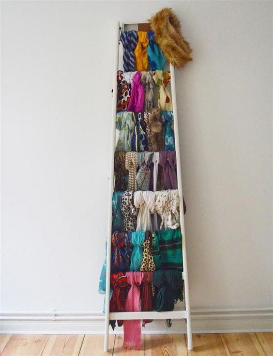 how to hang scarves in a closet. an old ladder with scarves hanging from it.