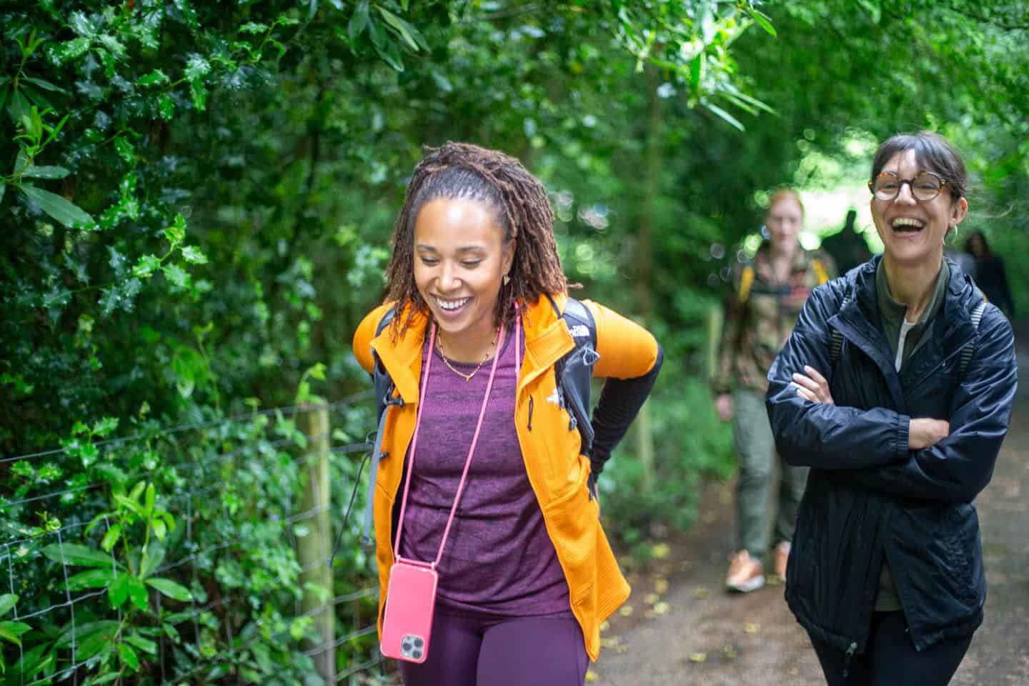 Women enjoying outdoor walk in lush green park in London.
