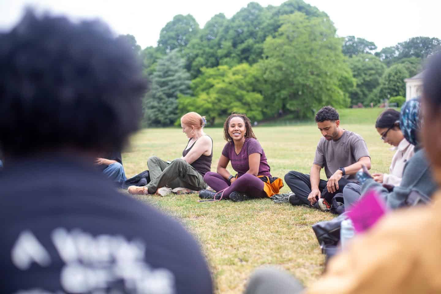 Diverse group of people sitting on grass at outdoor community event in London.