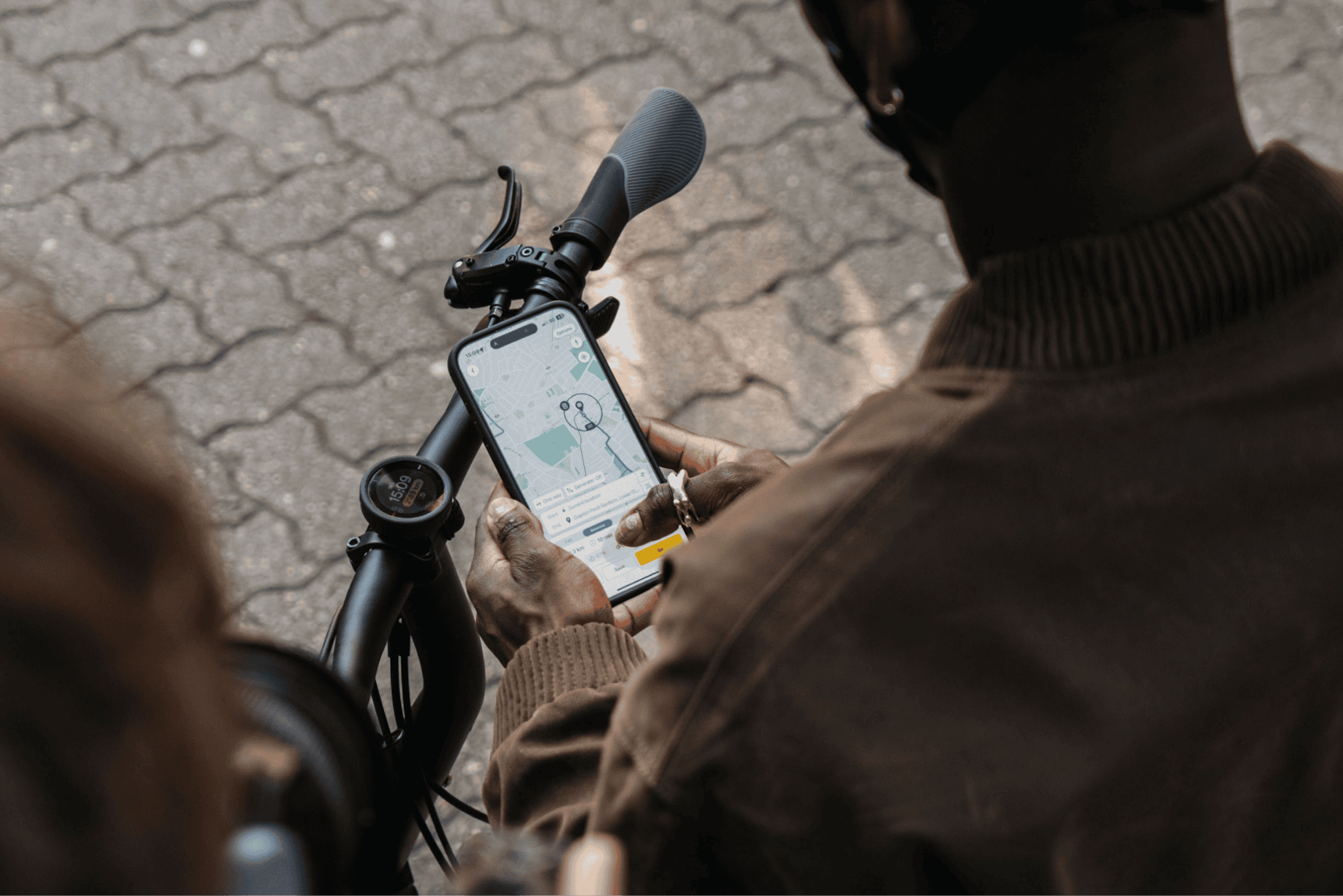 Motorcycle rider checking a GPS navigation app on smartphone for outdoor adventure.