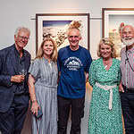 Group of happy people at an outdoor exploration or travel event in a gallery setting, showcasing outdoor adventure and mountaineering themes.