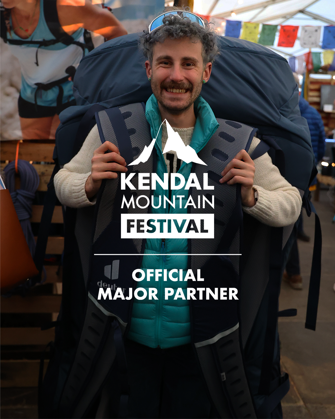 Adventure backpacker at Kendal Mountain Festival, surrounded by outdoor gear and vibrant festival atmosphere.
