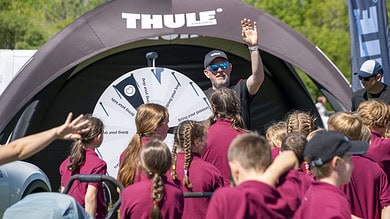 Outdoor Insight showcasing Thule products at a mountain festival with a group of children.