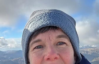 EOCA General Manager in snowy pastures with mountains in the background.
