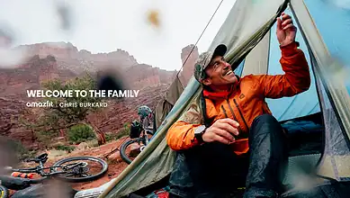 Young man camping in Red Rock Canyon with mountain biking gear nearby.