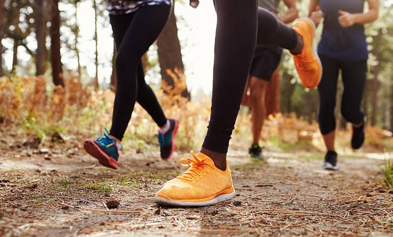 Running shoes on a forest trail during outdoor exercise.