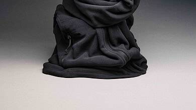 Crushed black hoodie with zipper pocket on a grey background.