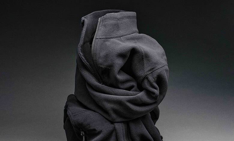 Crushed black hoodie with zipper pocket on a grey background.