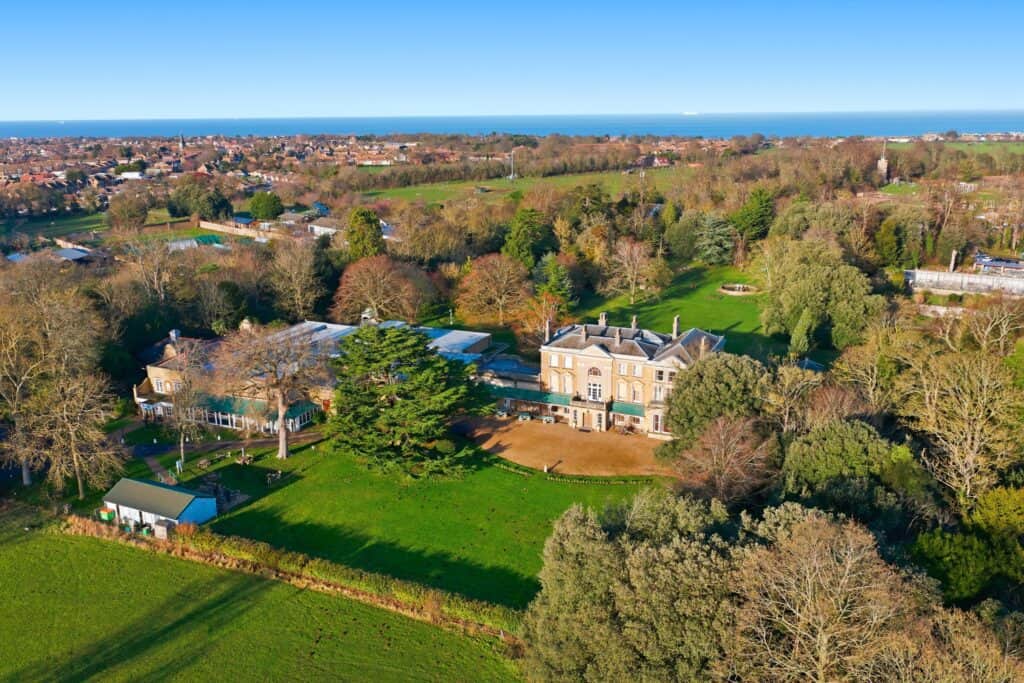Aerial view of Quex Park estate with historic house and lush gardens.