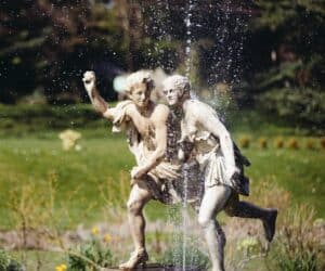 Children playing in a water fountain sculpture at Quex Park.
