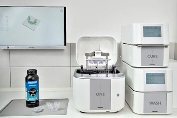 The ONE 3D Printing Solution, including the ONE wash and the ONE cure, RS Print Studio, and a dental resin bottle in a dental clinic.