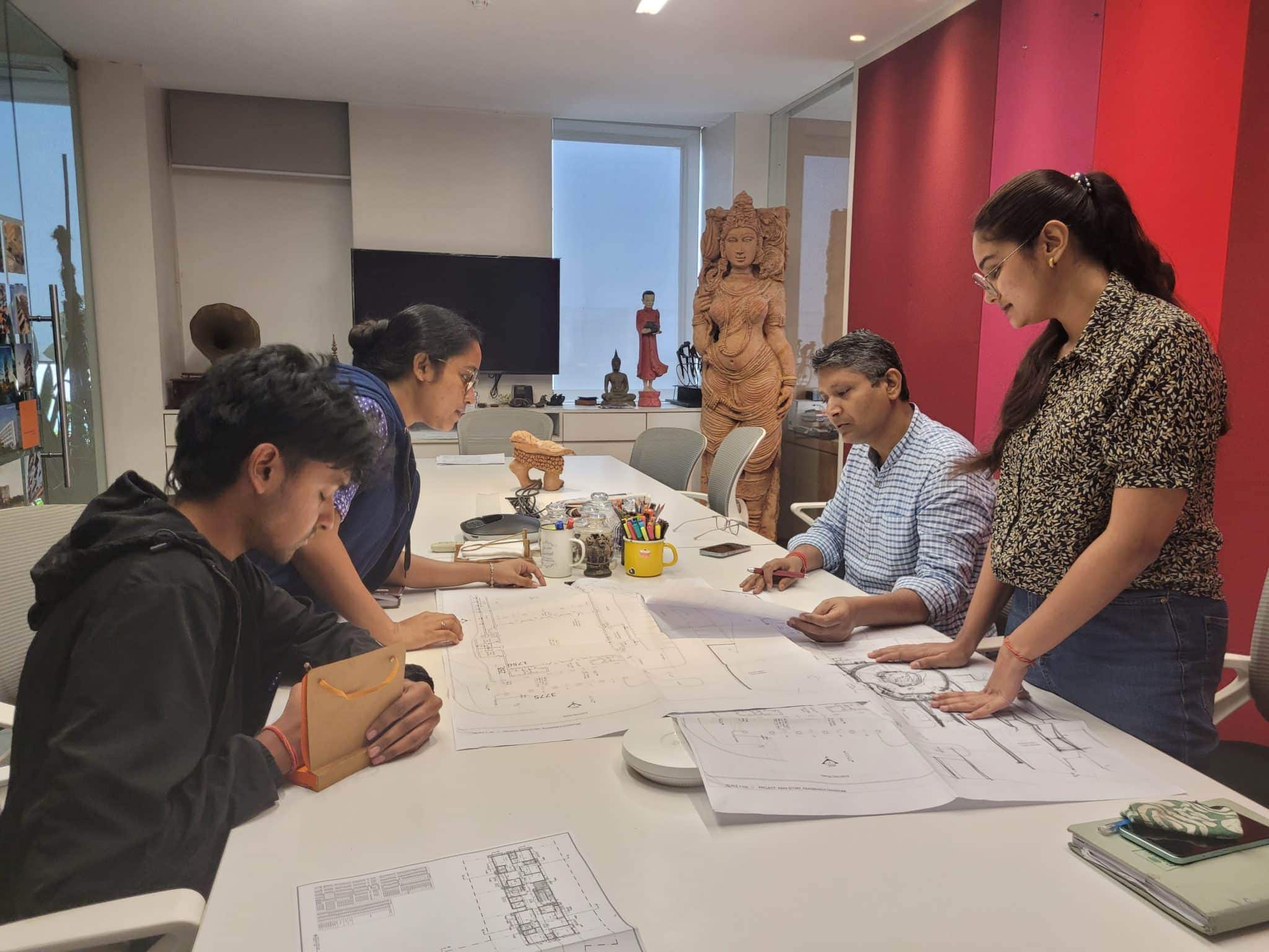 Architectural design team collaborating on blueprints and plans at Salient Design Studio office.