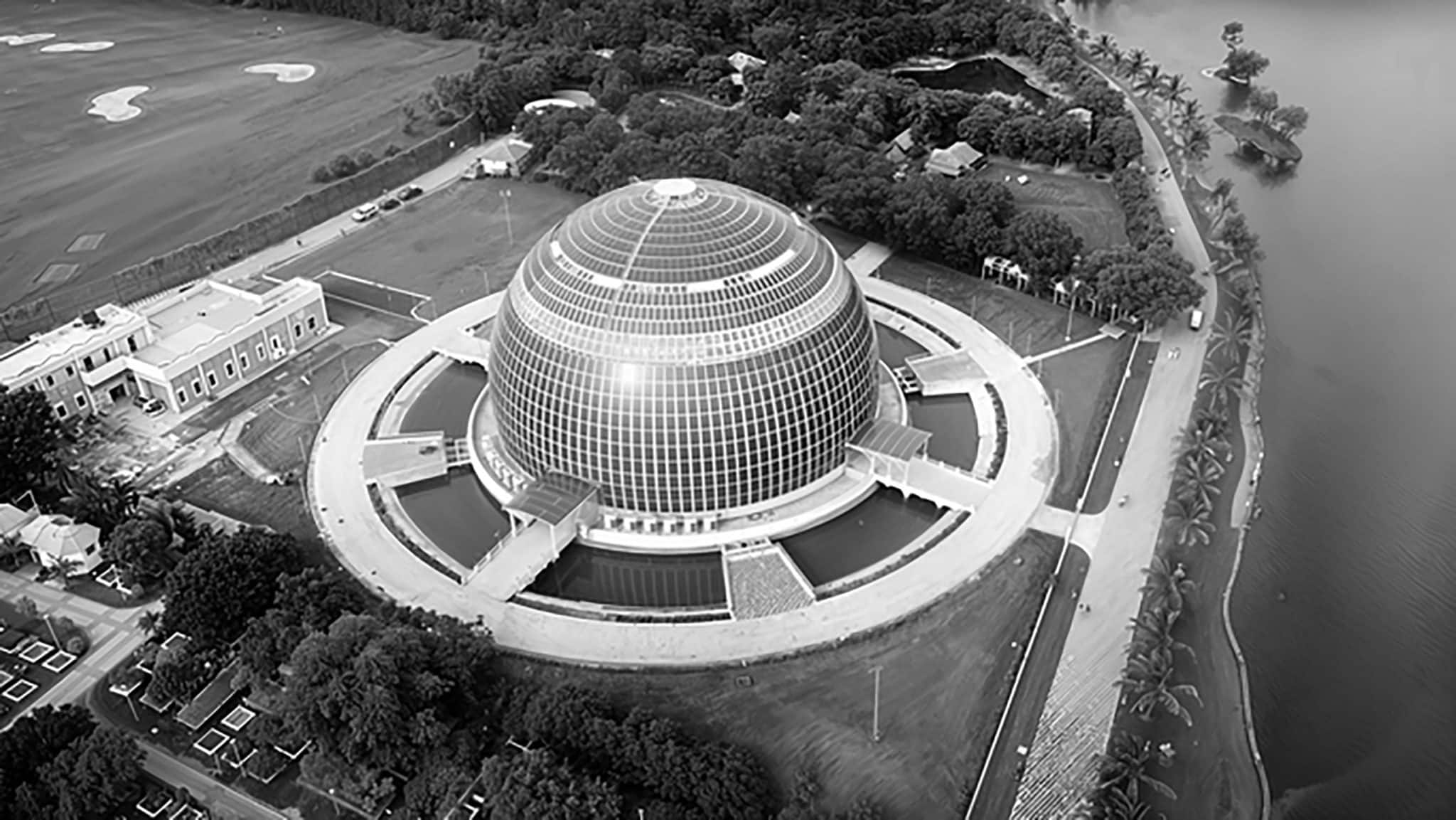 Modern glass dome conference center with scenic waterfront location.