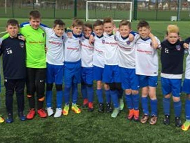 Sandbach United youth football team posing on the field before a match.
