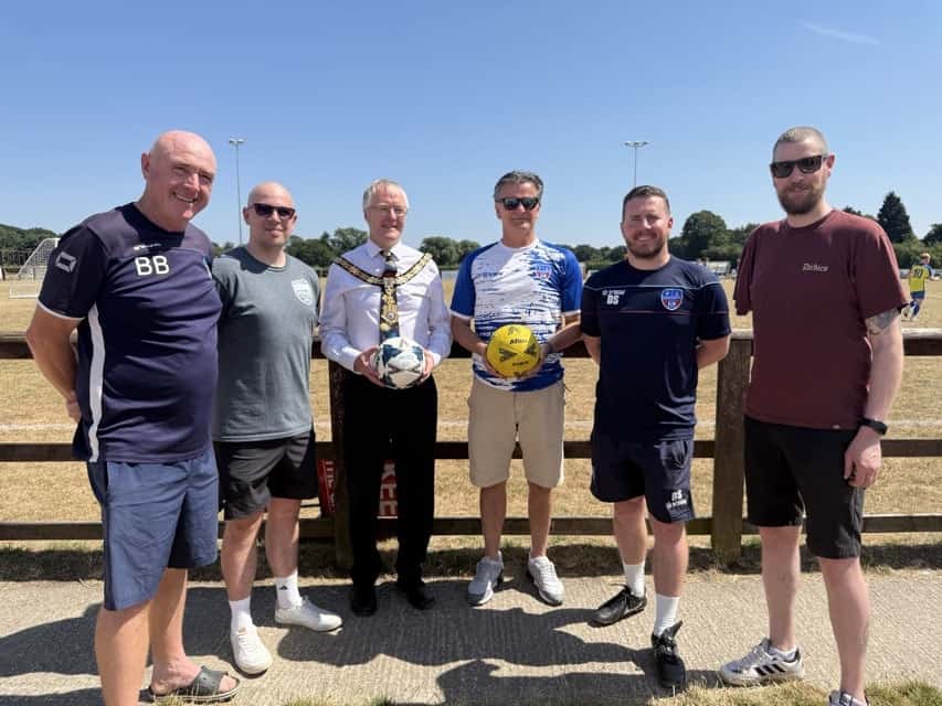 Sandbach United team members and officials at a community event.