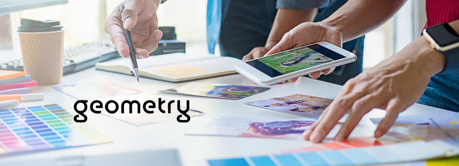 A group of diverse individuals gathered around a table, engaged in looking at pictures and discussing them. The scene includes various office supplies scattered on the table, reflecting an atmosphere of learning and creativity.