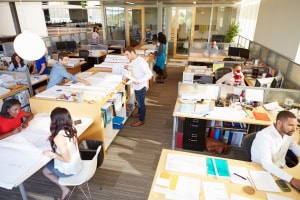 A modern classroom with students working at desks and teachers assisting.