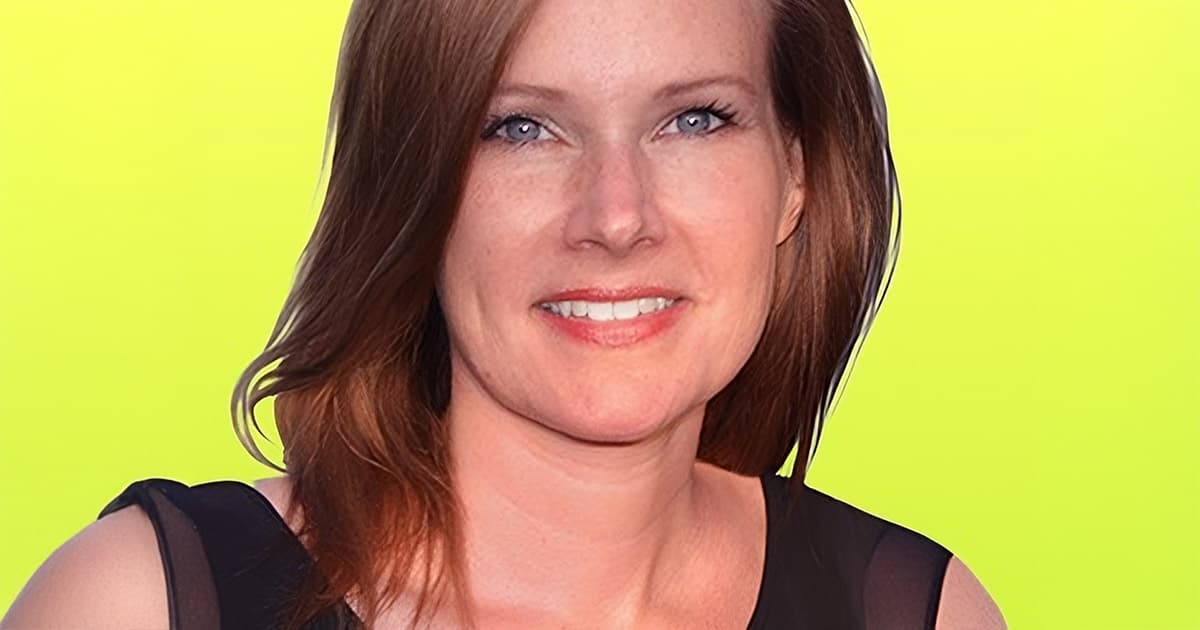 A smiling woman with shoulder-length brown hair against a bright yellow background.