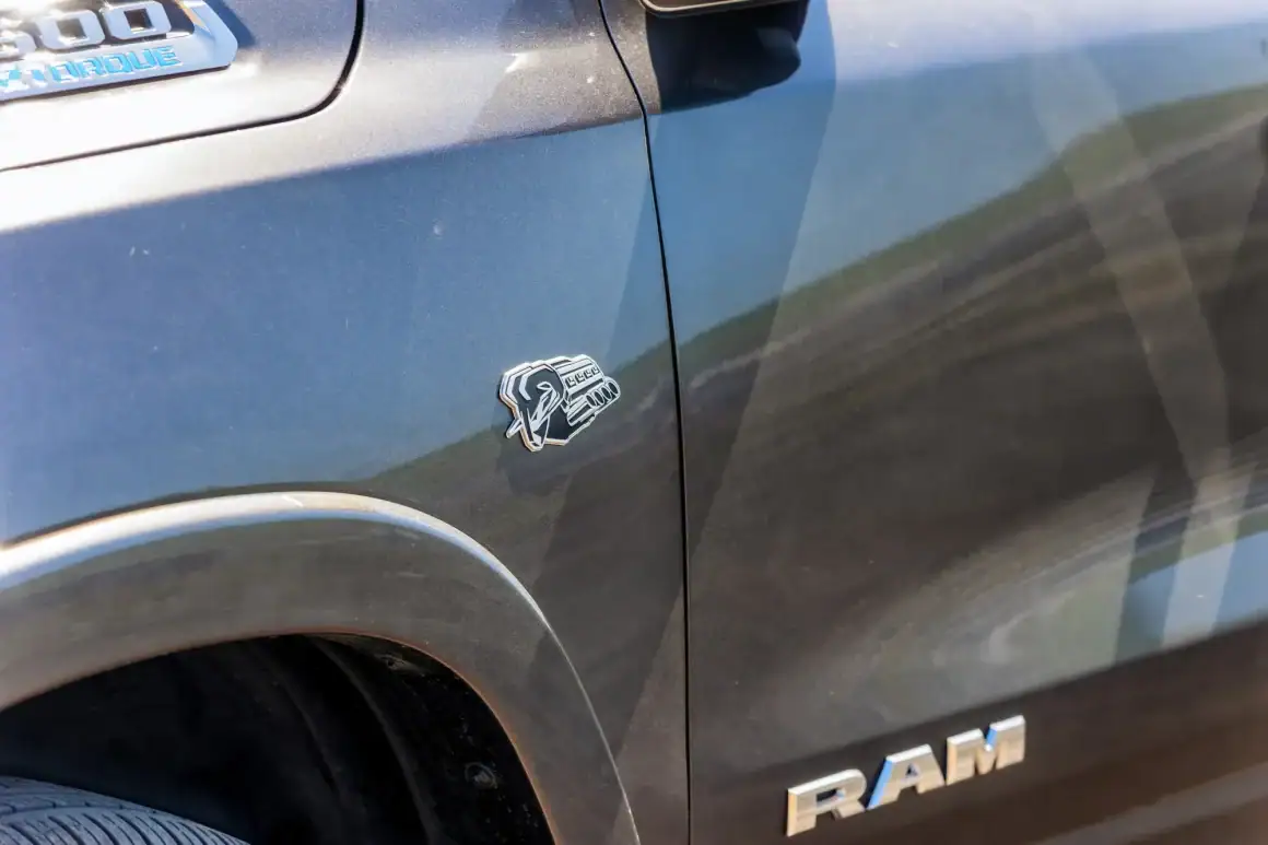 Close-up of Ram 1500 Limited Longhorn badge on dark gray truck.