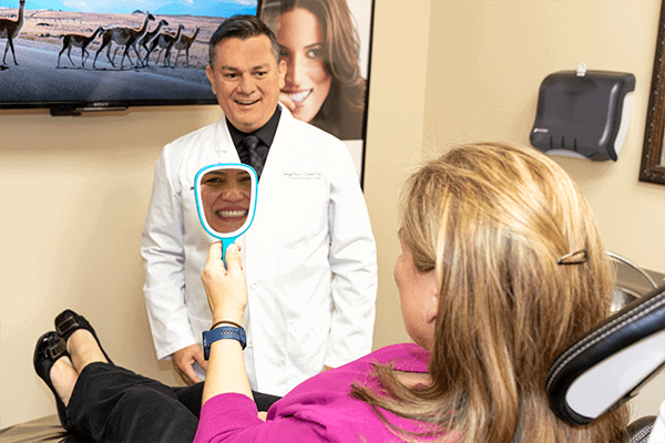 A patient checking her smile on a mirror