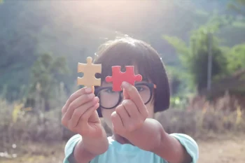 little girl holding puzzle pieces little girl holding puzzle pieces