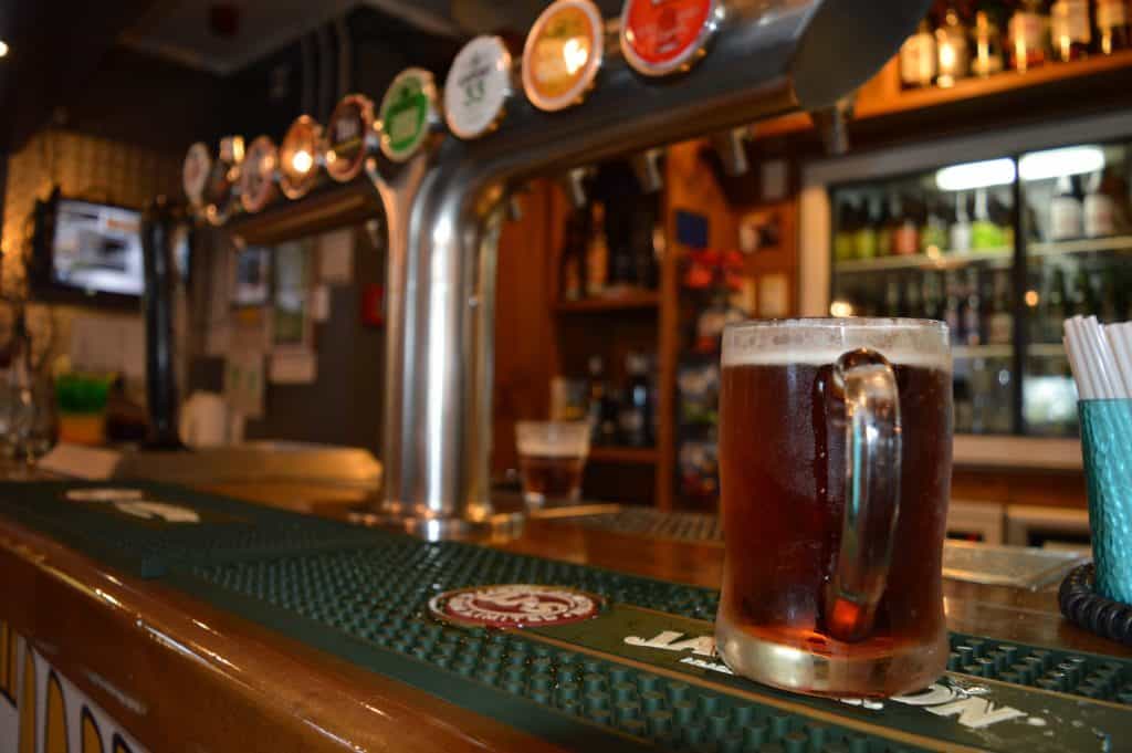 Cold beer on tap at Stumble Inn pub, a popular NZ nightlife spot for locals and visitors.
