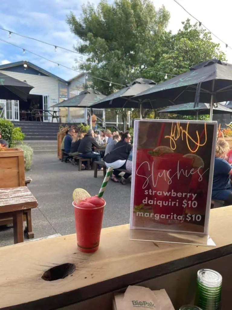 Vibrant outdoor bar at Stumble Inn with customers enjoying drinks and socialising on a sunny day.