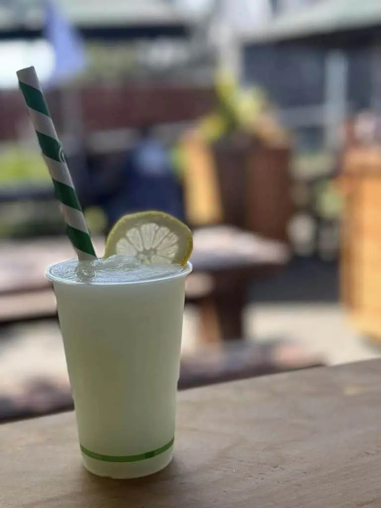Refreshing lemon drink at Stumble Inn with straw and lemon garnish, perfect for relaxing outdoors.