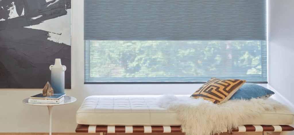 Soft pink roller sun shades for window privacy and light control in a cozy sunroom.