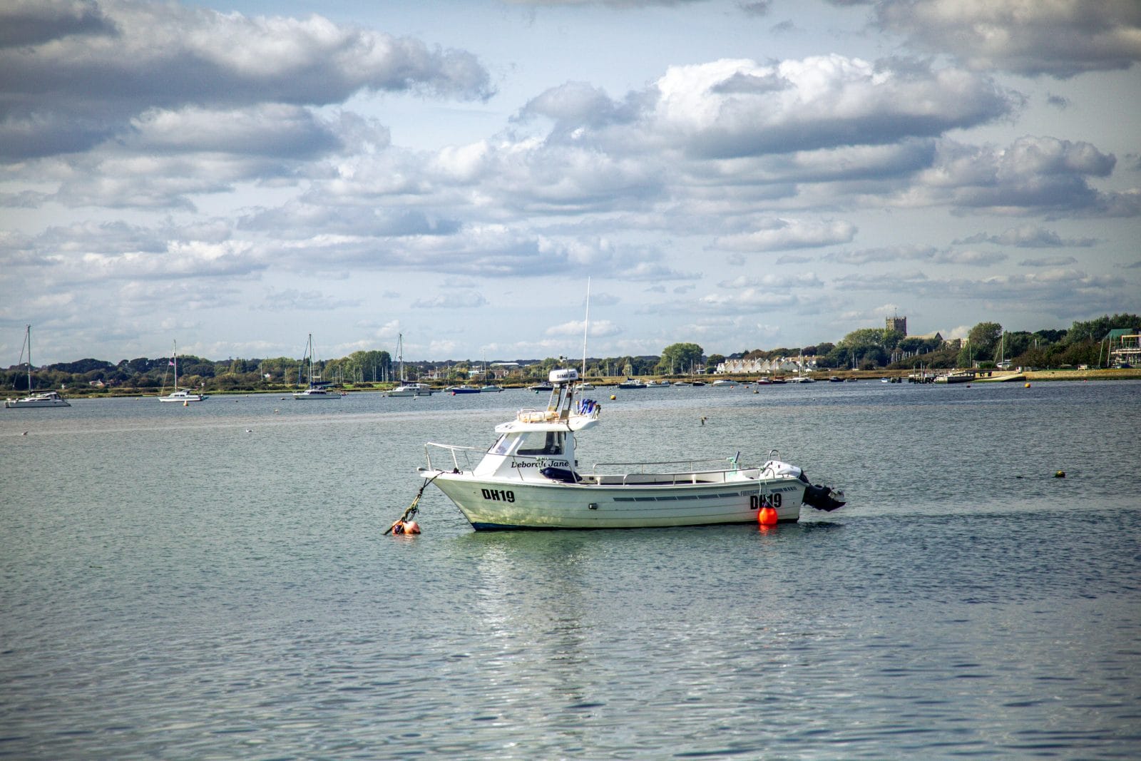 picture of a boat out as sea near a harbour