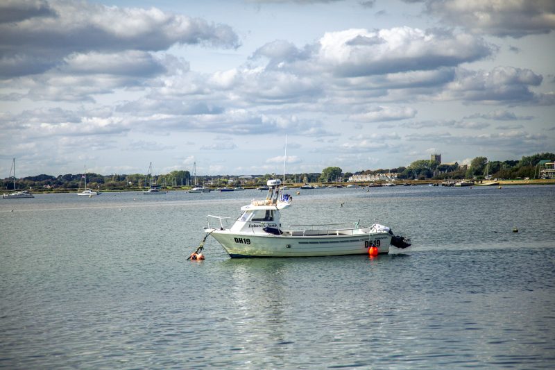 picture of a boat out as sea near a harbour