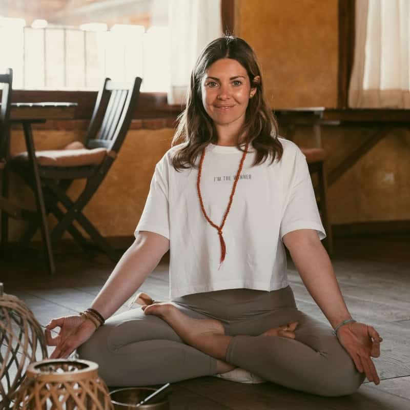 Donna che pratica yoga in un ambiente caldo e accogliente.