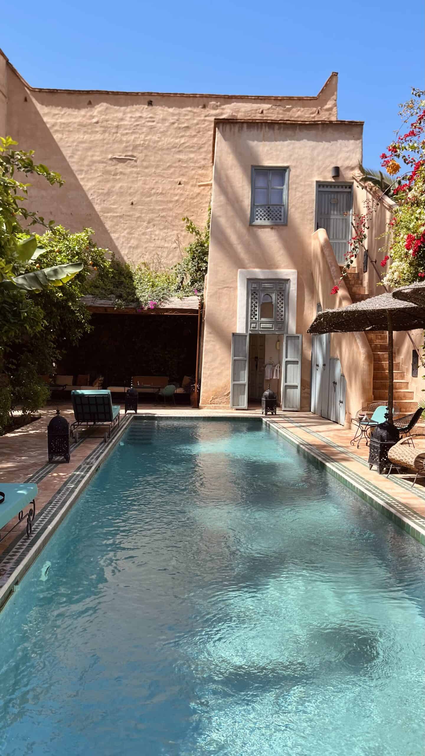 Piscina all'aperto con edificio e area relax presso TAB Yoga in Italia.