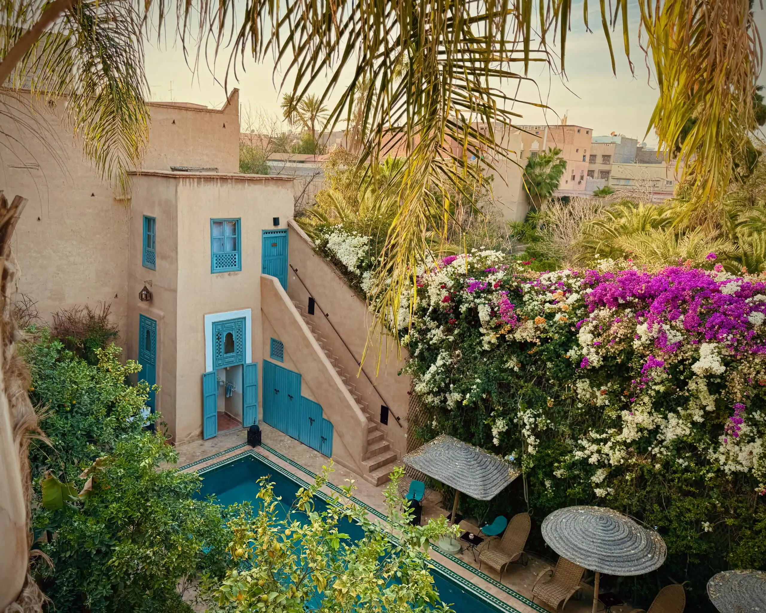 Giardino con piscina, ombrelloni e piante tropicali a Tab Yoga.