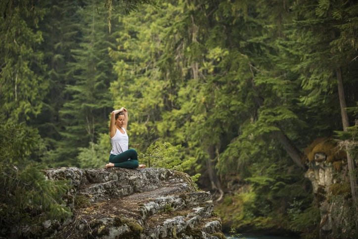 Tourisme responsable : devenir un voyageur éclairé femme qui médite dans la nature
