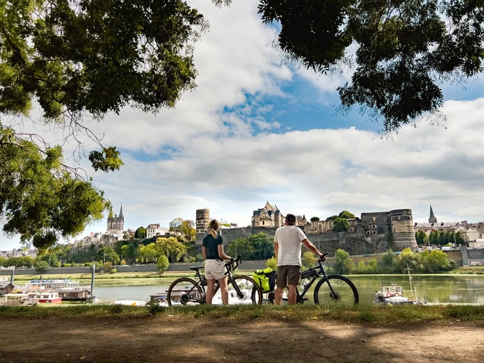 où aller pour un séjour à la saint-valentin ? couple de cyclistes regardant le château d'angers.