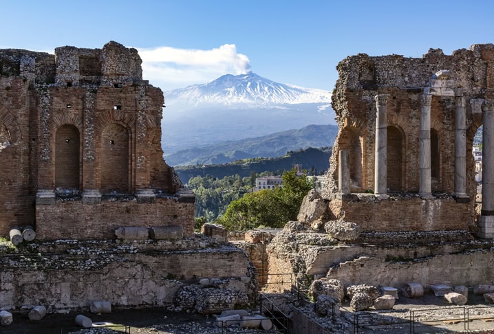  vue sur le volcan etna, à travers les ruines de l'amphithéâtre de taormine, sicile