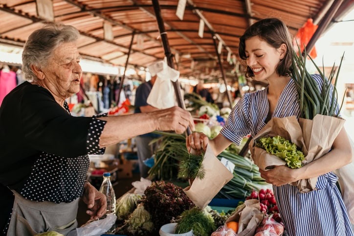 Voyager permet-il de prendre conscience de la crise climatique ? femme soutenant les communautés locales. femme qui achète fruits et légumes au marché