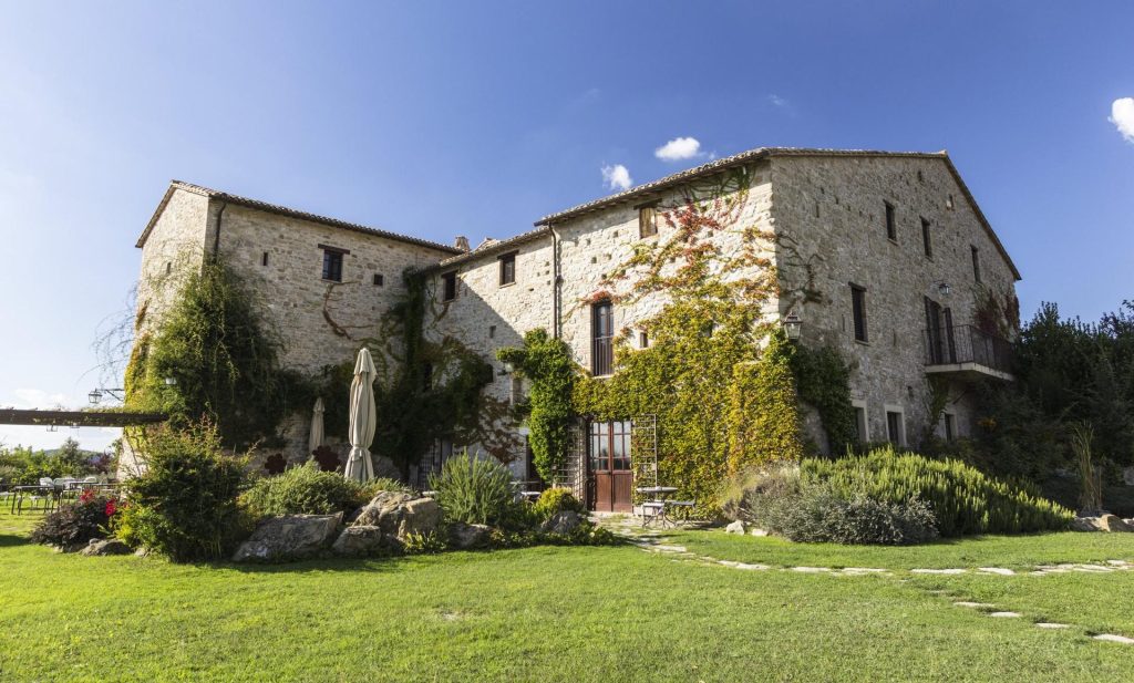 Voyage dans le cœur vert de l’Italie : itinéraire à la découverte de la région Ombrie vue de la façade de castello di petrata, maison teritoria en ombrie et troisième étape du voyage en ombrie