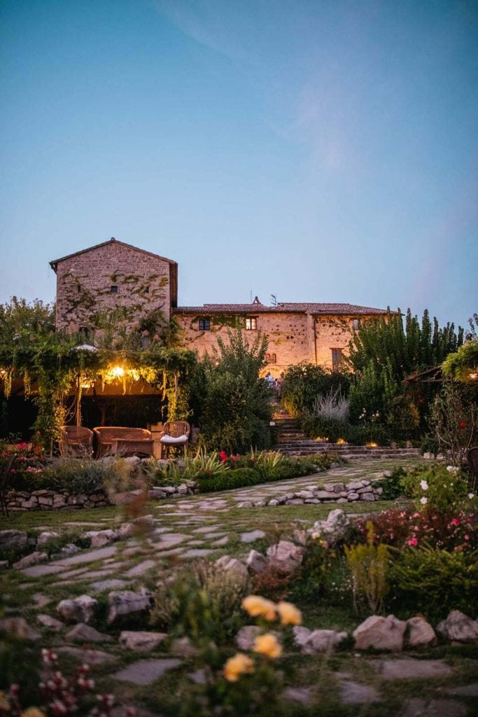 Voyage dans le cœur vert de l’Italie : itinéraire à la découverte de la région Ombrie façade de castello di petrata, maison teritoria en ombrie, le soir