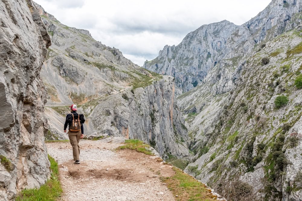 Où partir en juin en Europe shutterstock 2525730767 cimagodens une touriste faisant de la randonnee dans les gorges pittoresques de cares dans les montagnes des picos de europa asturies dans le nord de lespagne