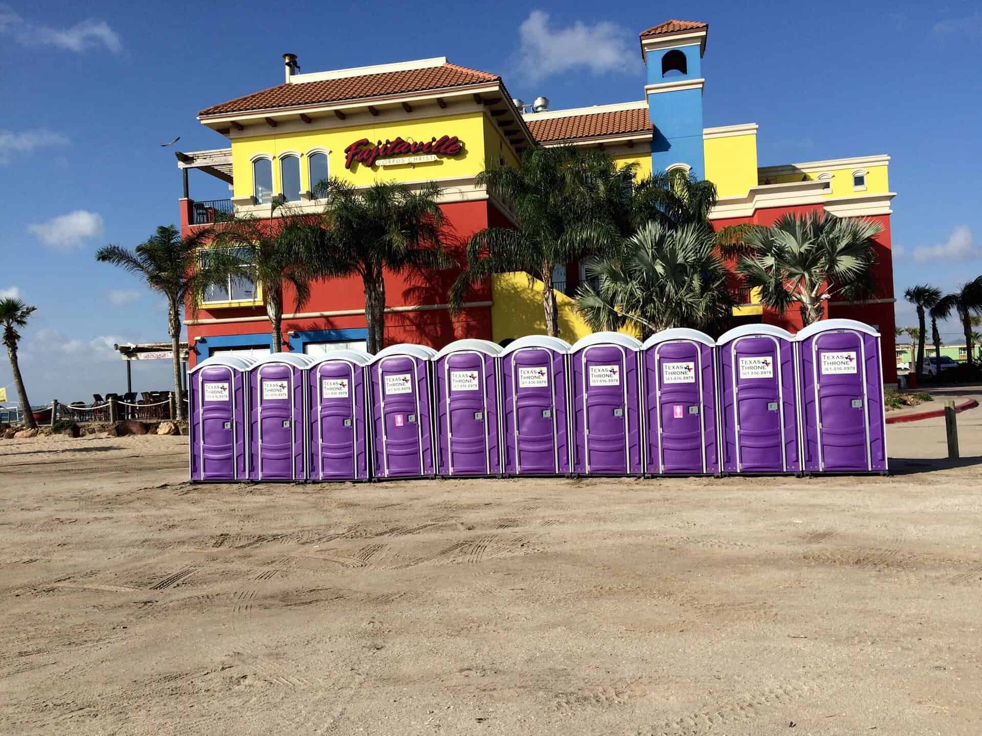 Portable toilets in front of colorful Texas Throne building, showcasing outdoor restroom rental services.