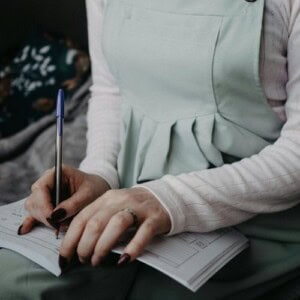 A person writing in a diary, practising journaling for healing.