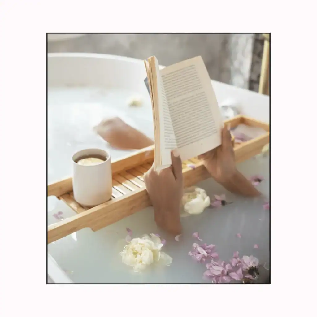 A-woman-having-a-bath-flower-petals-reads-a-book