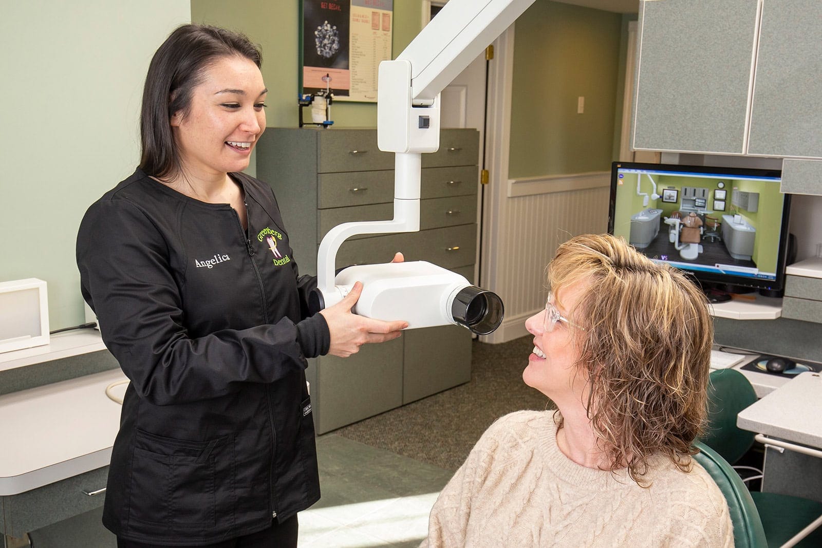A dental assistant begins to scan a patient's teeth
