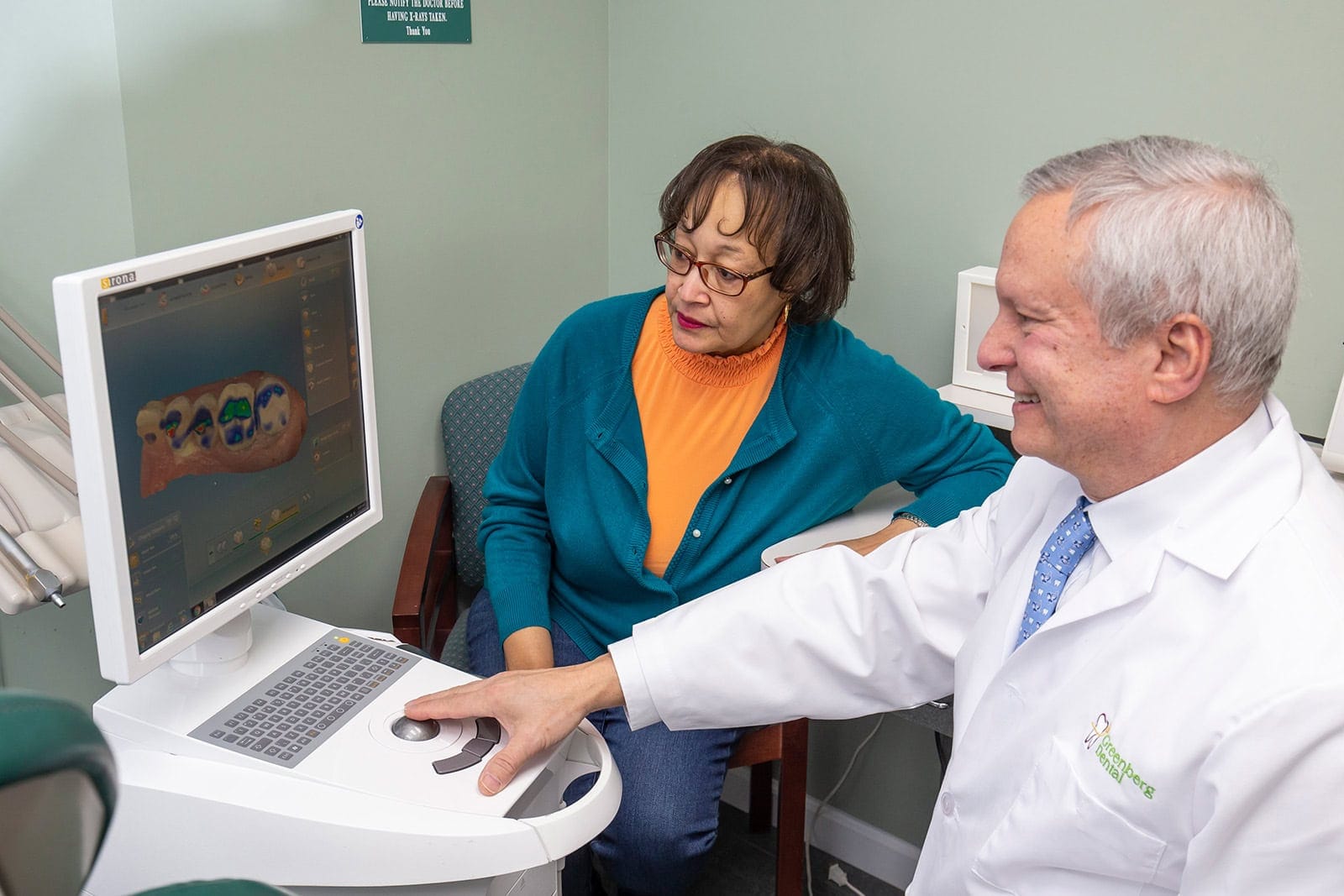 Dr. Randy Greenberg shows a patient scanned teeth on a CEREC scanner