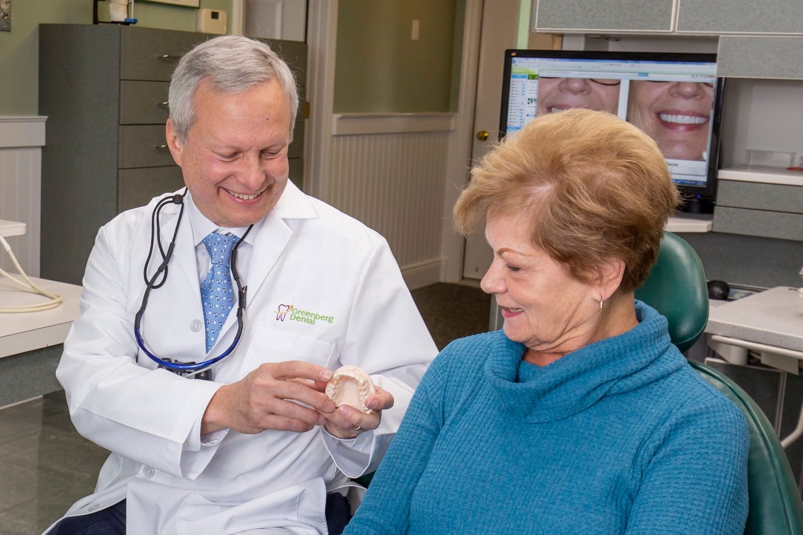 Dr. Randy Greenberg shows a patient a 3D teeth model