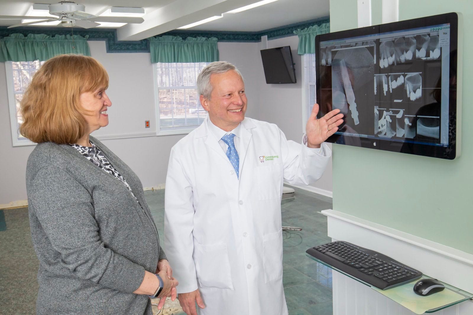 Dr. Randy Greenberg shows a patient an implant X-ray